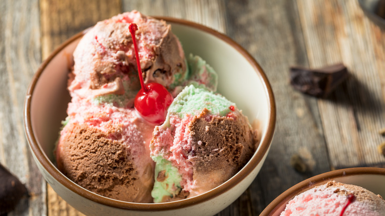 Bowl of spumoni ice cream with maraschino cherry