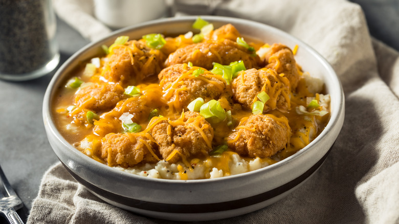 A homemade mashed potato bowl with popcorn chicken and gravy