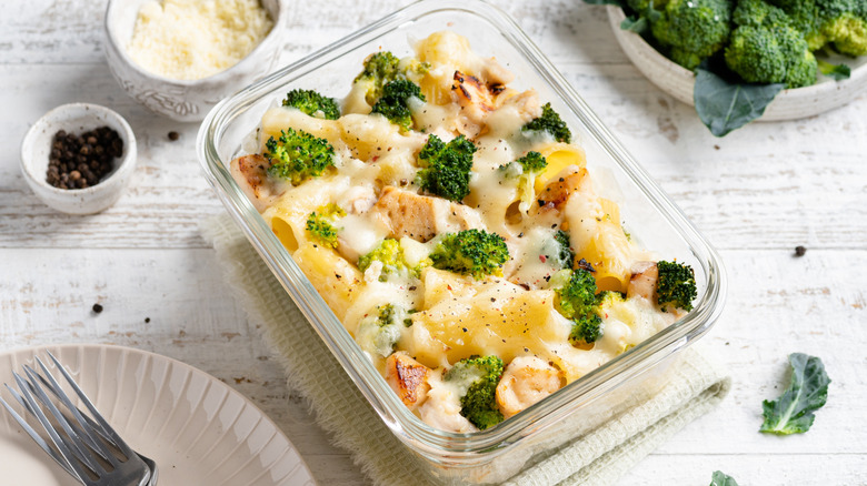 A small glass baking dish of macaroni and cheese with chicken and broccoli