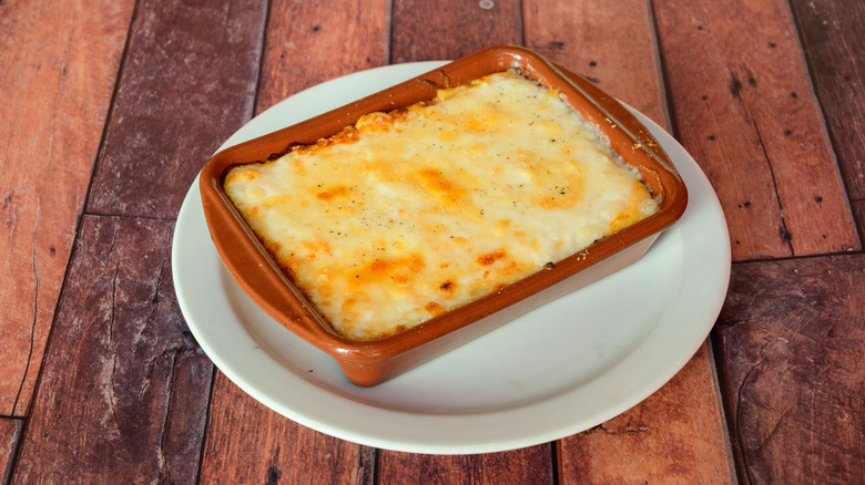 A small ceramic baking dish filled with melted cheese