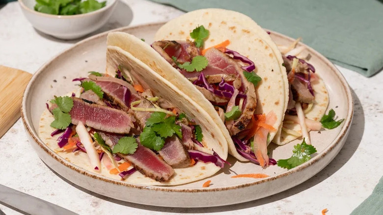 spicy tuna tacos with ginger slaw on a plate