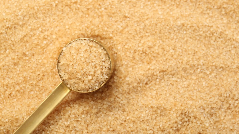 Granulated sugar in a golden scoop.
