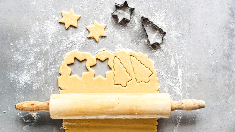 Rolled out cookie dough with rolling pins and cutters.