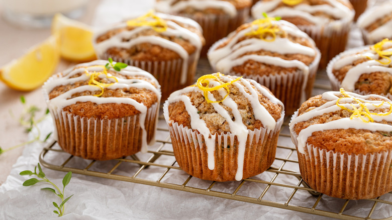 Muffins with shredded zucchini and icing on a cooling rack