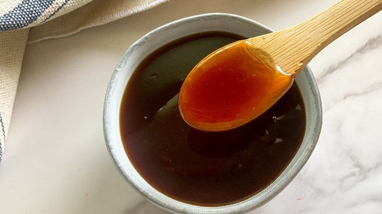 Spooning sweet and sour sauce out of small bowl