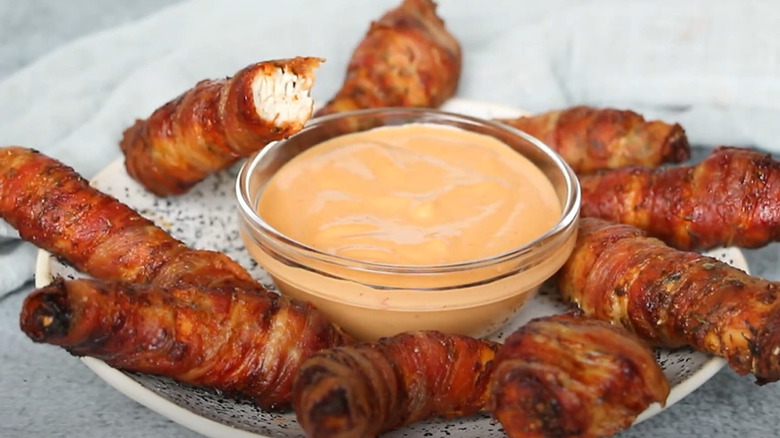 Bacon-wrapped chicken tenders with bowl of spicy mayo
