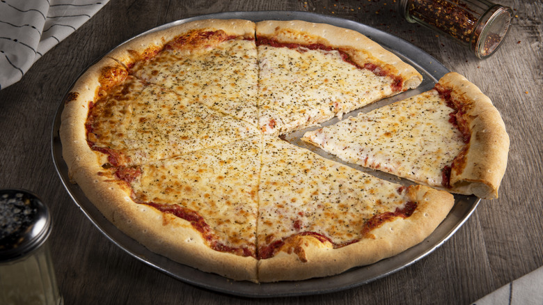 A large, extra cheesy cheese pizza on an aluminum pizza pan