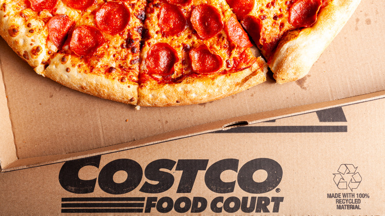 A pepperoni pizza in a cardboard takeout box labeled Costco Food Court