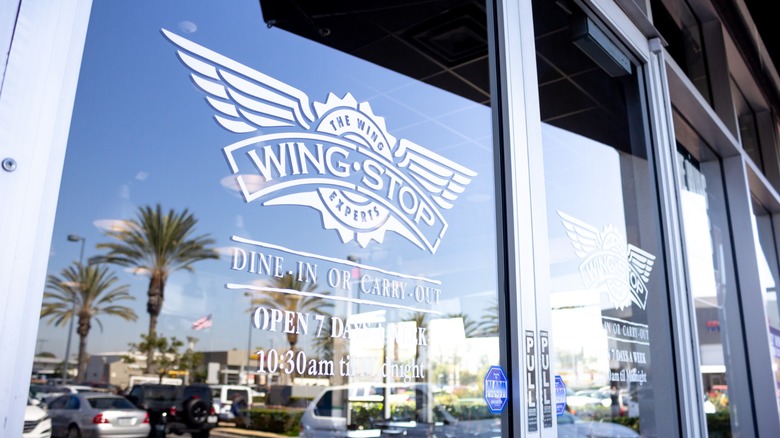 Wingstop's aviation-inspired logo on the front doors of a restaurant
