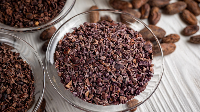 cacao nibs in a bowl with cacao beans in background