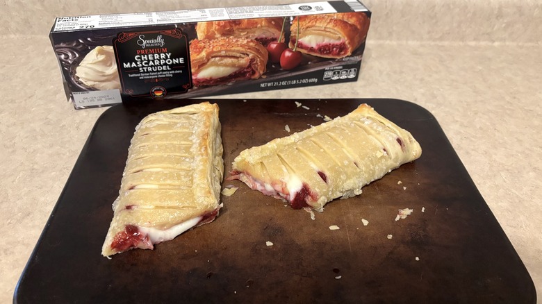 Cherry mascarpone strudel on a baking stone on neutral background.
