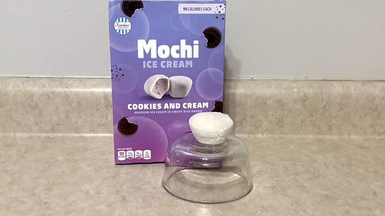 Cookies and cream mochi ice cream in box and on a bowl on neutral background.