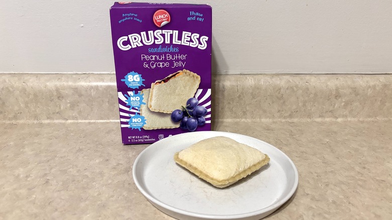 Peanut butter and grape jelly crustless thaw and eat sandwiches in a box and on a plate.