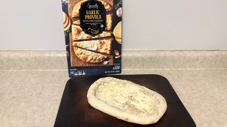 Garlic provola flatbread in box and on baking stone on neutral background.