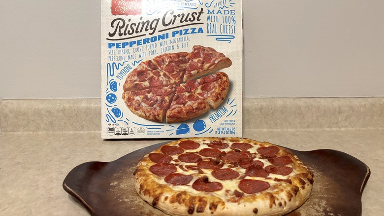 Pepperoni rising crust pizza in box and on a baking stone on neutral background.