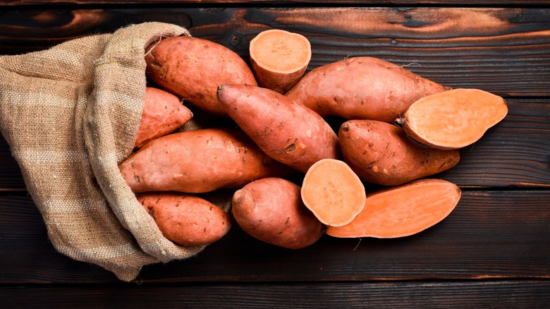 Raw sweet potatoes spilling out of bag