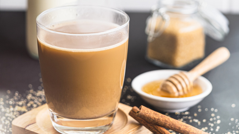 A cup of coffee with honey in background
