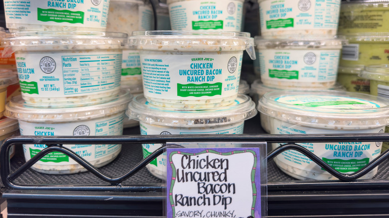 Containers of Trader Joe's Chicken Uncured Bacon Ranch Dip on shelf in store