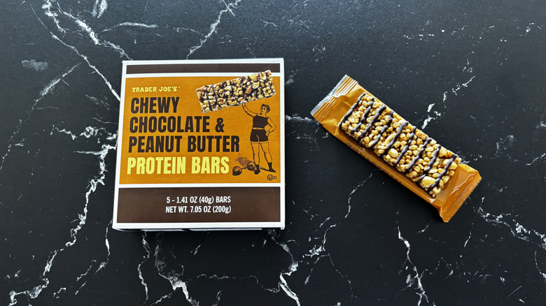 Trader Joe's chocolate peanut butter protein bars box next to unwrapped bar