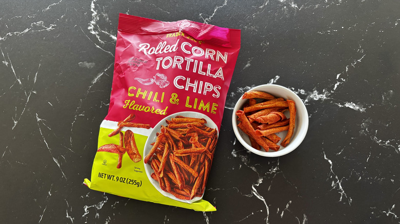 Trader Joe's chili lime rolled tortilla chips bag next to small bowl with chili lime chips