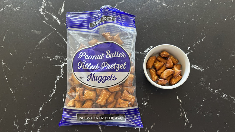 Trader Joe's peanut butter pretzel nuggets bag next to small bowl with pretzel nuggets