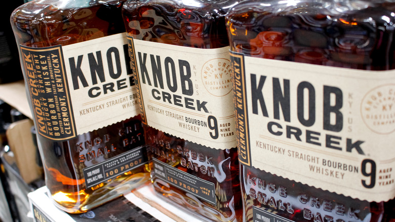 A row of Knob Creek 9-year bottles showcased on a liquor shelf