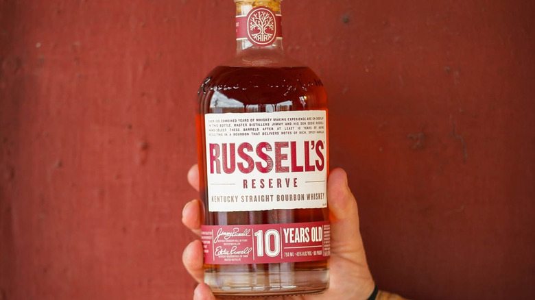 A person holding up a bottle of Russell's Reserve 10 Year up to the camera