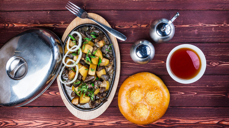 a plate of Kuurdak with tea and bread