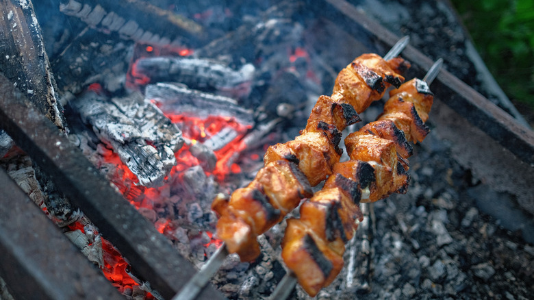 two shaslik skewers over a fire