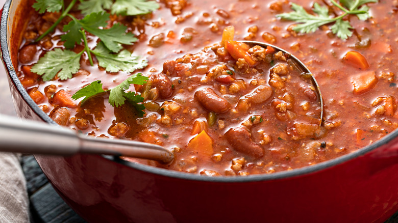 A pot of chili with ladle.