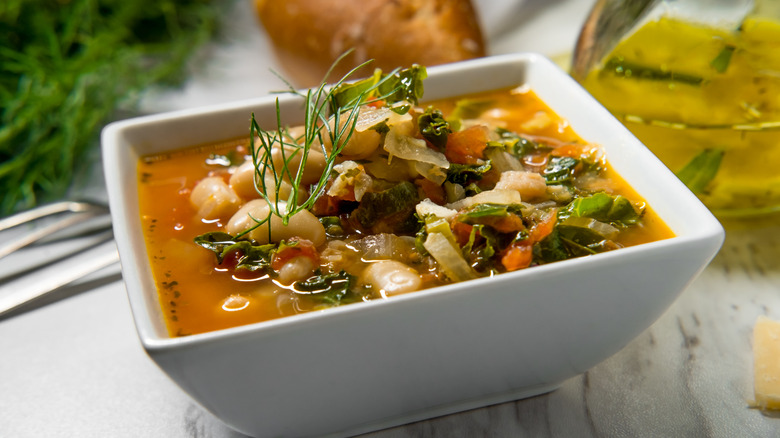 A white square bowl of ribollita.