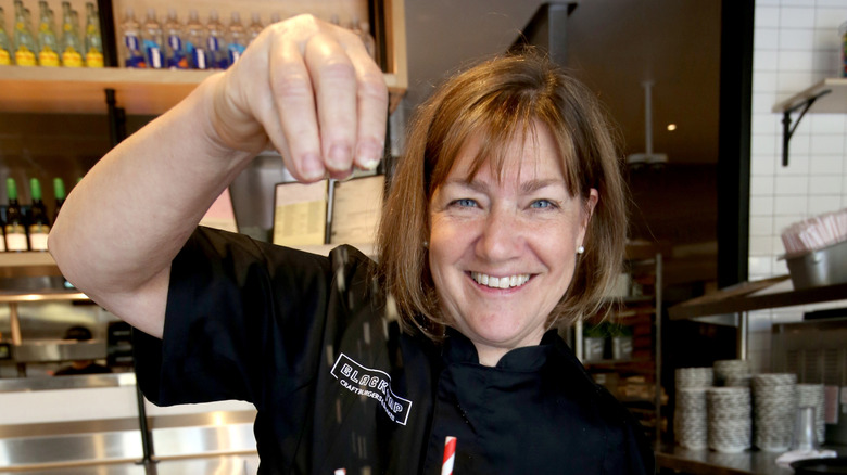 Gale Gand smiling while dropping toppings