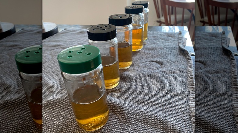 Spice jars with holes poked in the lids hold a solution to attract flies.