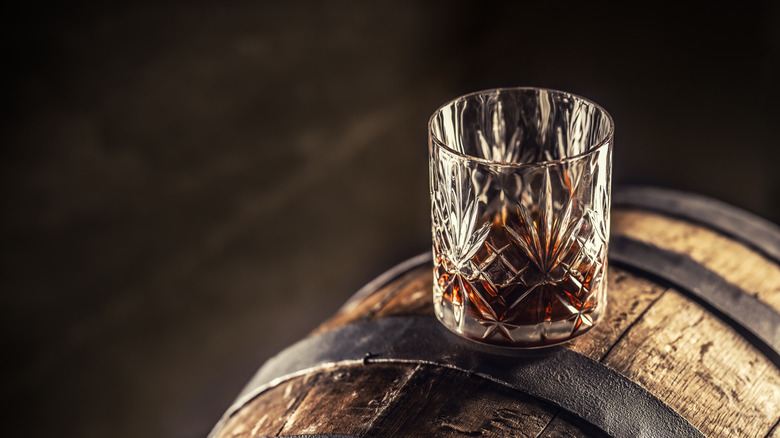Glass of bourbon on a wooden cask