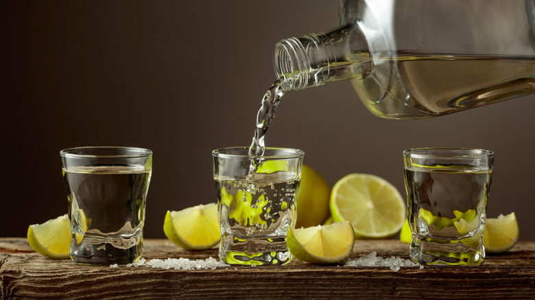 Shot glasses of tequila with limes