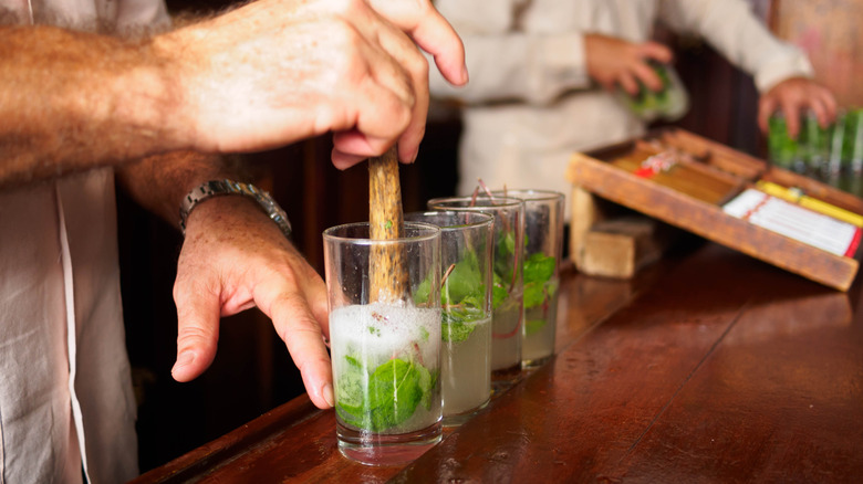 Bartender muddling mojitos