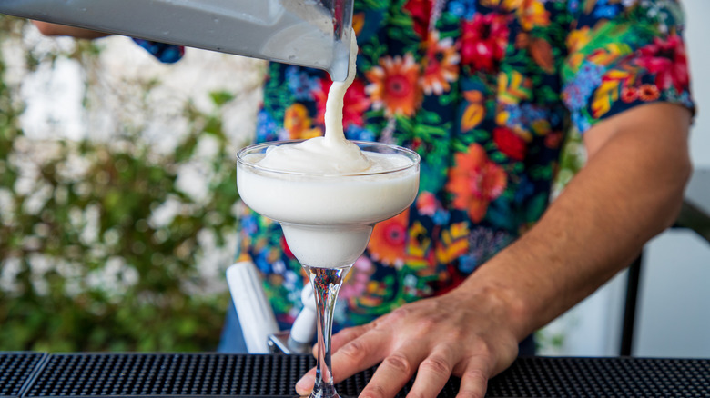 Bartender pouring frozen cocktail from blender