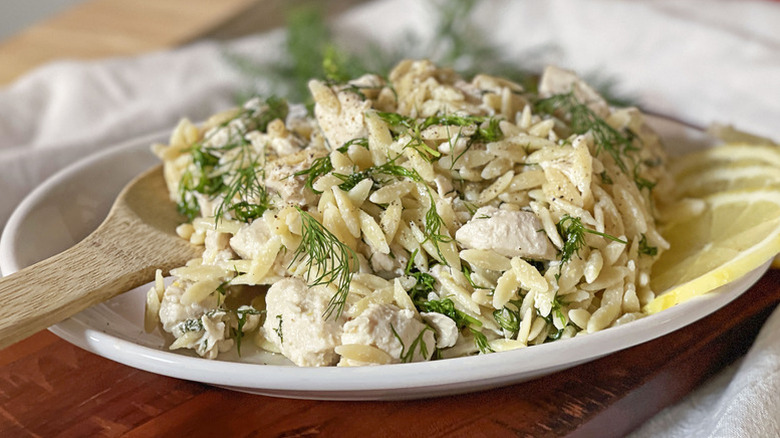 Plate of chicken orzo salad garnished with fresh dill