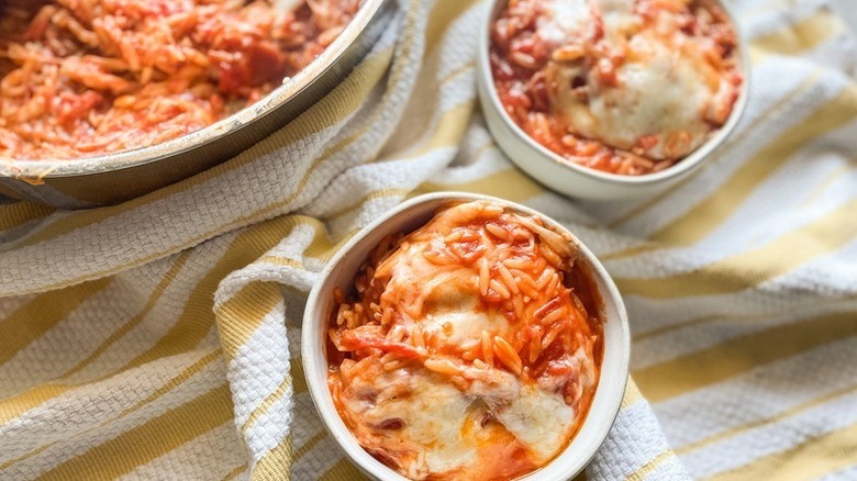 Cheese and tomato orzo bake in white bowls
