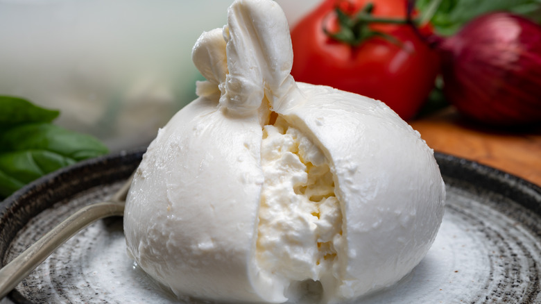 Close up of burrata on plate, sliced open to show inside