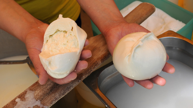 Two balls of burrata being made by hand in Italy