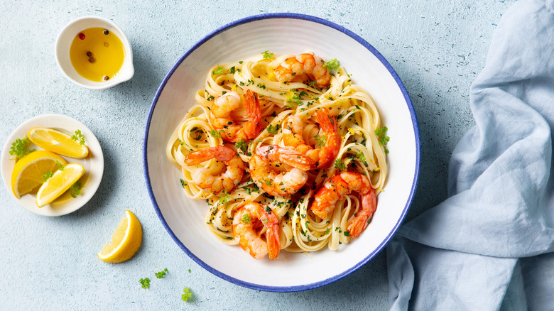 Shrimp over pasta with lemon and oil on the side