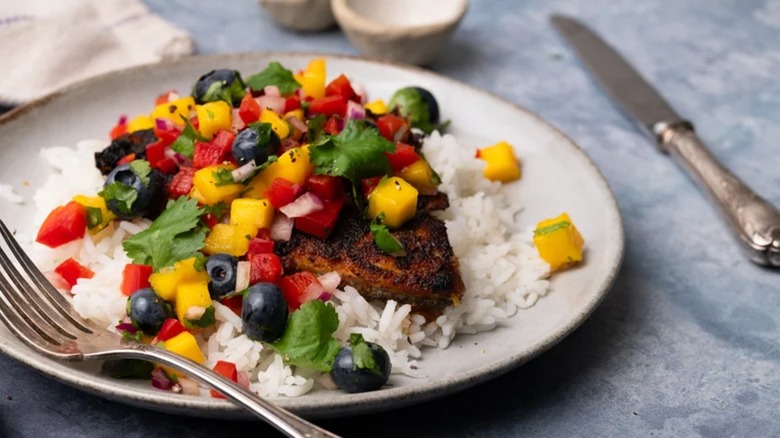 Blackened fish over white rice and topped with mango salsa