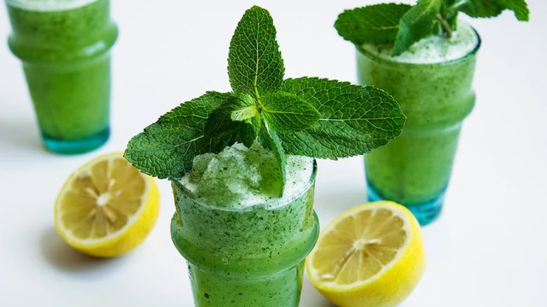 Three frozen mint lemonades with lemon halves