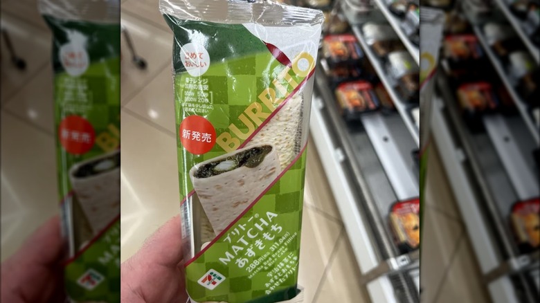 Person holding packaged 7-eleven matcha burrito inside store