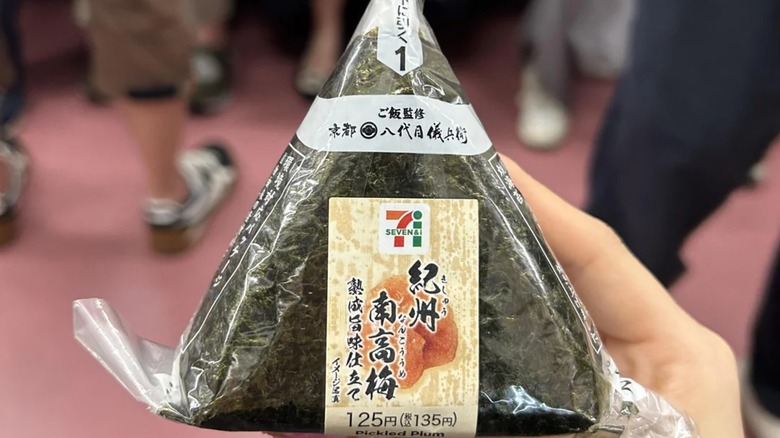 Hand holding pickled plum onigiri from 7-eleven