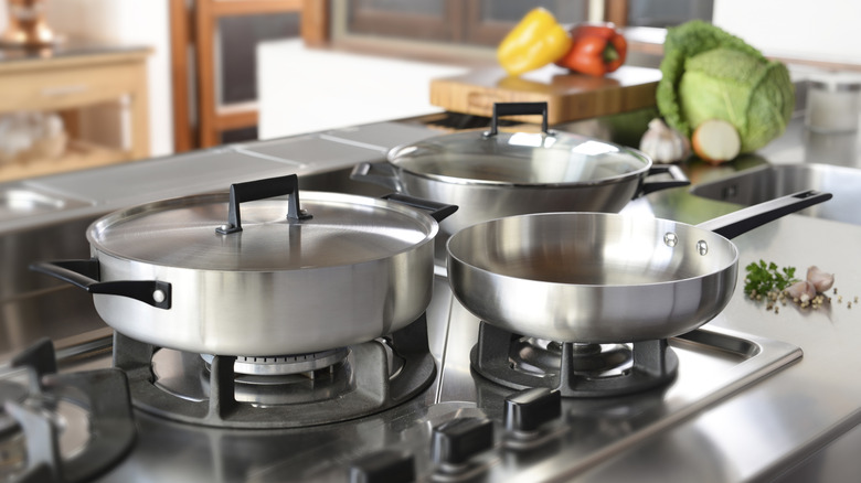 A variety of aluminum pans on a kitchen stove