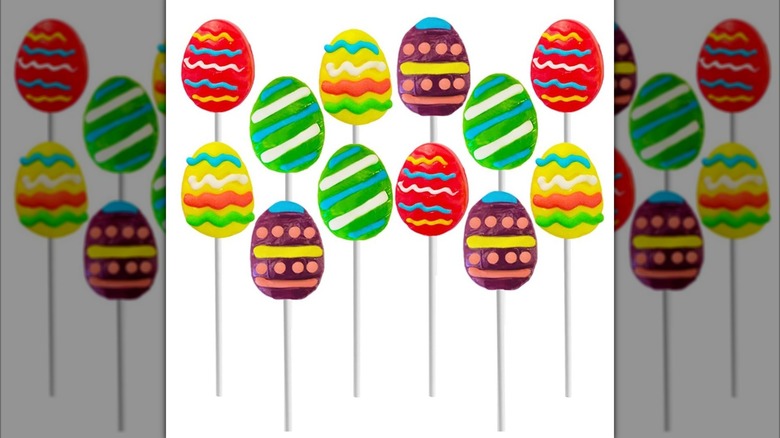 Various Fruidles Easter Egg Lollipops with colorful striped and dotted designs on white background