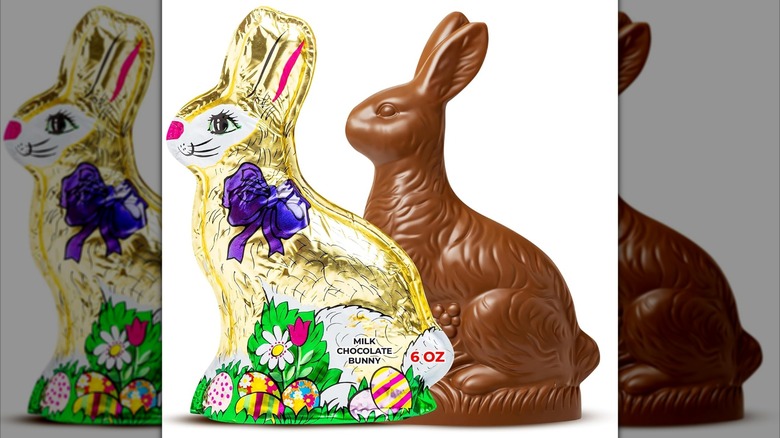 Madelaine Large Chocolate Bunny wrapped in gold foil next to unwrapped chocolate bunny on white background