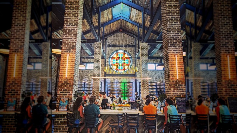 Interior of Burnt Church Distillery displaying the bar and a prominent stained glass window